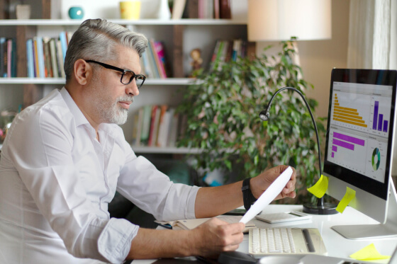Business man looking at financial graphs on computer