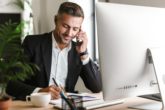 Business man at his desk on the phone with support