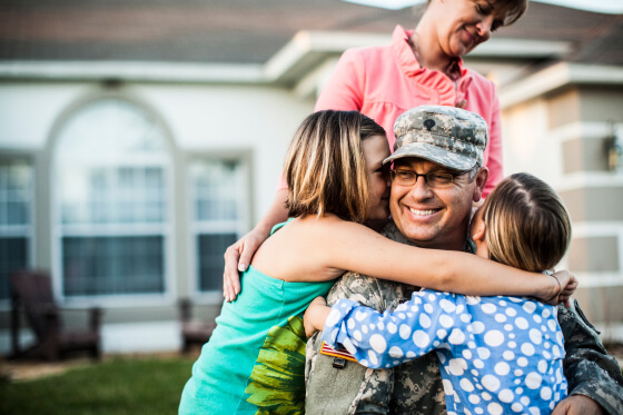 Male soldier hugging family